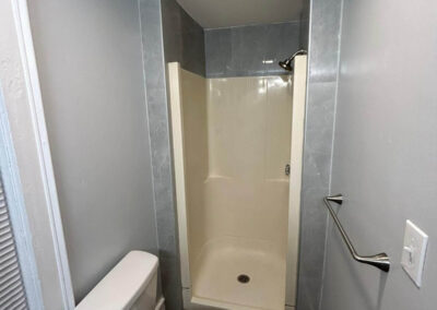 bathroom with a high commode and shower space