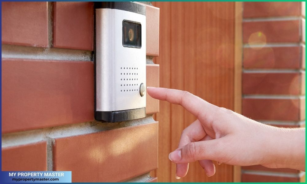 Hand presses a button doorbell with a camera and intercom