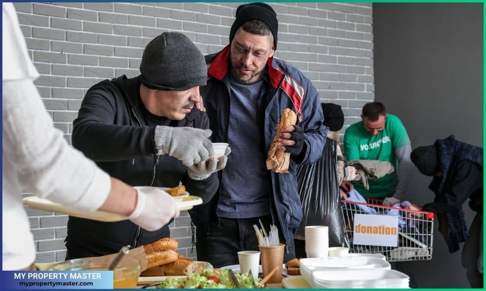 Volunteer Giving Food to Homeless People in Warming Center