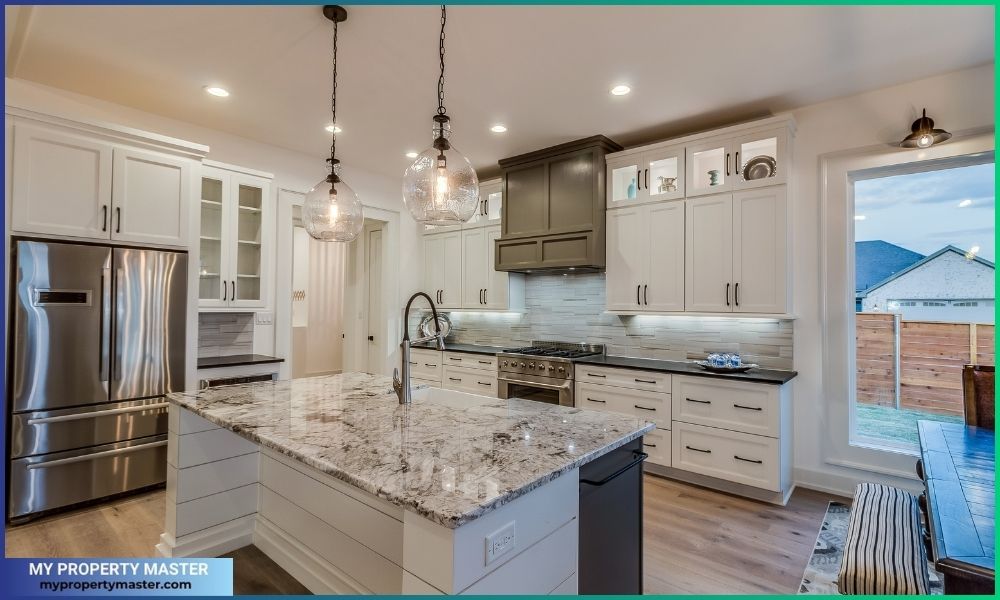 Granite countertops and two pendant lights above the island