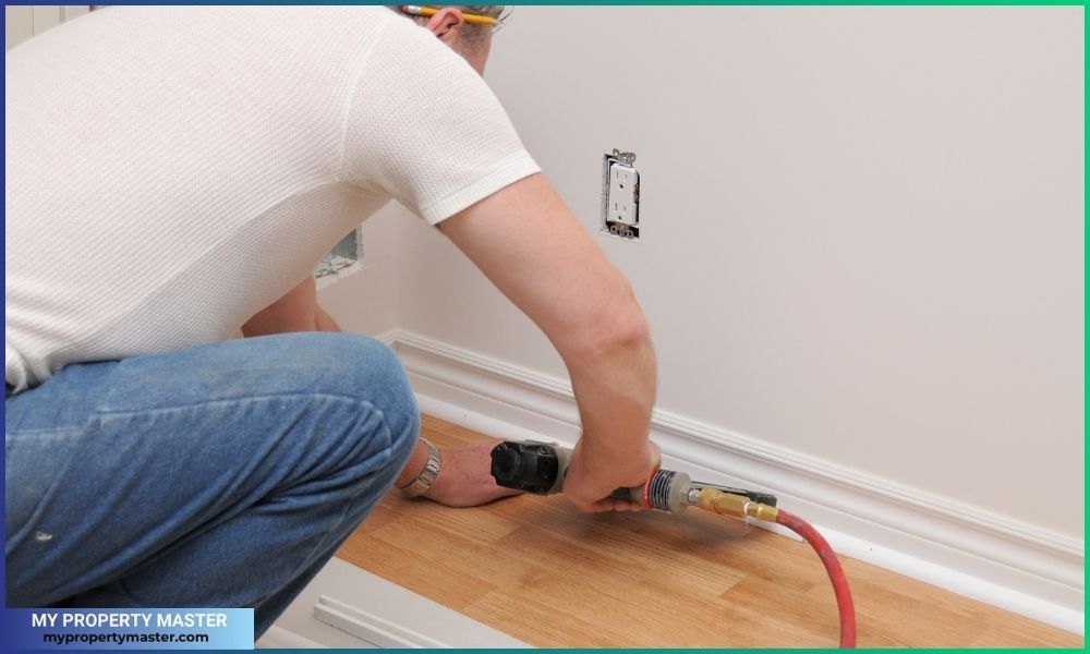 Man working with a nail gun, Laminate floor installation