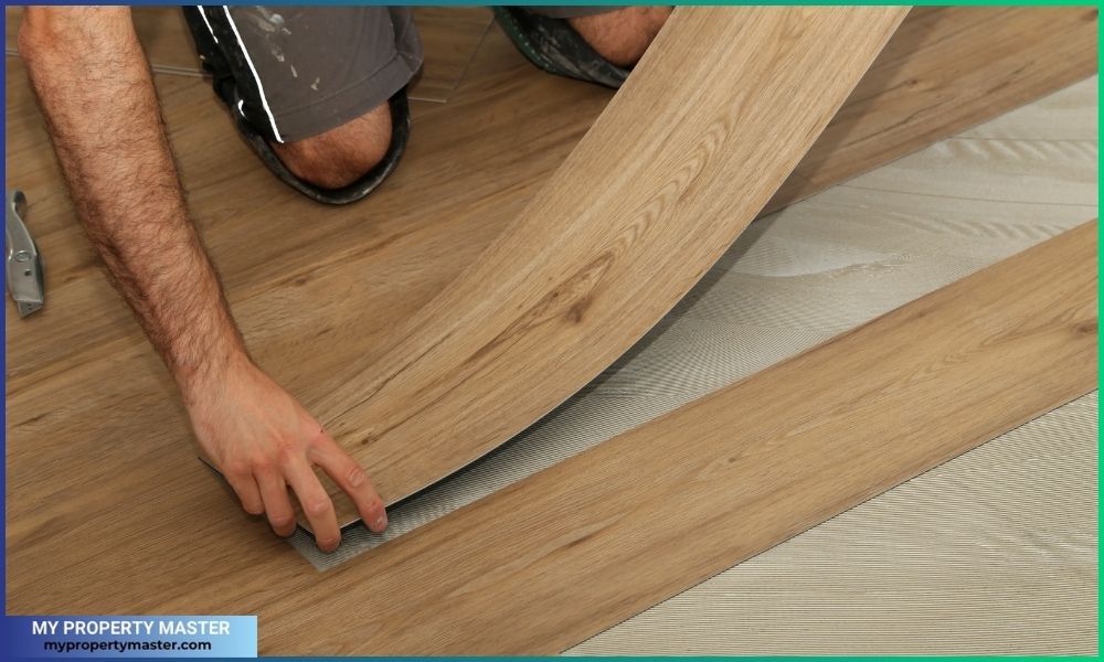 The worker installing new vinyl tile floor